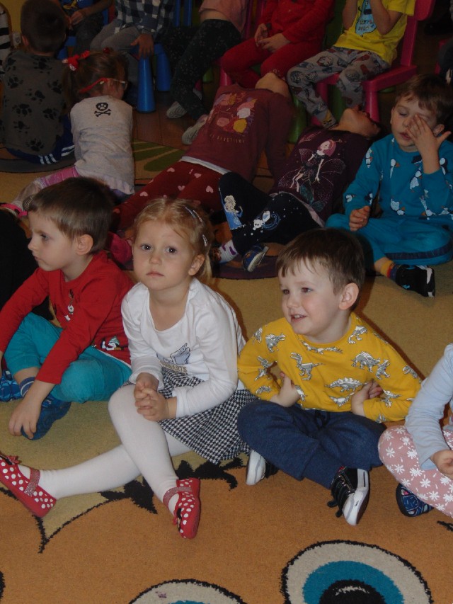 Grupa przedszkolaków siedzi na podłodze
